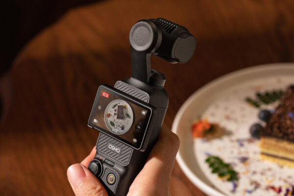 DJI Osmo Pocket 3を手に持ち、テーブルの上のデザートを撮影している様子。次期モデルOsmo Pocket 4の噂記事のアイキャッチ画像。